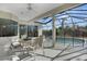 An outdoor patio with ceiling fan, and a table with four chairs overlooking a screened-in pool area at 14205 Nighthawk Ter, Lakewood Ranch, FL 34202