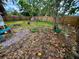 A fenced backyard featuring a mix of brick, tree coverage, and grassy areas at 1520 2Nd E Ave, Bradenton, FL 34208