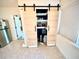 Pantry in kitchen with light wood sliding barn doors and modern shelving for ample storage at 1520 2Nd E Ave, Bradenton, FL 34208