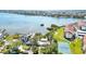 Beautiful waterfront aerial view of a home with a tennis court and lush landscaping with mature trees at 1621 Memory Ln, Sarasota, FL 34231