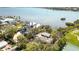 Overhead shot of a waterfront property, surrounded by lush trees and with a tennis court nearby at 1621 Memory Ln, Sarasota, FL 34231