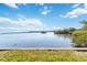 A tranquil bay view with vibrant mangroves, calm waters, and a bright, expansive sky with scattered clouds at 1621 Memory Ln, Sarasota, FL 34231