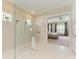 Contemporary bathroom with glass enclosed walk-in shower and neutral tile, open to bedroom at 16218 Umbria Pl, Bradenton, FL 34211