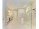 Modern bathroom featuring a glass-enclosed shower, double vanity, and sleek tile flooring at 16218 Umbria Pl, Bradenton, FL 34211