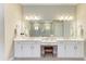 Bright bathroom featuring double vanity, white cabinets, marble countertops, and a large mirror with modern lighting at 16218 Umbria Pl, Bradenton, FL 34211