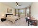 Bright bedroom featuring neutral carpet, large windows, ceiling fan and a work station with a desk at 16218 Umbria Pl, Bradenton, FL 34211