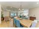 Open-concept dining area featuring a dining table, chandelier, and a seamless flow to living room and kitchen at 16218 Umbria Pl, Bradenton, FL 34211