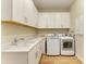 Convenient laundry room with washer, dryer, utility sink, and white cabinets at 16218 Umbria Pl, Bradenton, FL 34211