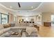 Open-concept living area with a large sectional sofa, wood floors, and views into the gourmet kitchen at 16218 Umbria Pl, Bradenton, FL 34211