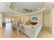 Spacious living room featuring a tray ceiling, neutral decor, wood floors, and an open layout at 16218 Umbria Pl, Bradenton, FL 34211