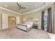 Bright main bedroom with neutral walls, tray ceiling, carpet, and ensuite bathroom access at 16218 Umbria Pl, Bradenton, FL 34211