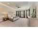 Serene main bedroom featuring a tray ceiling, plush carpet, neutral colors, and ample natural light at 16218 Umbria Pl, Bradenton, FL 34211