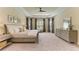 Calm main bedroom with neutral decor, carpet, tray ceiling, and large windows for plenty of light at 16218 Umbria Pl, Bradenton, FL 34211