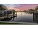 A waterfront property featuring a private dock with boat and water views at sunset at 1808 Flower Dr, Sarasota, FL 34239