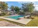 Backyard pool with a blue tiled edge and a concrete pool deck, surrounded by green grass at 205 45Th W St, Bradenton, FL 34209