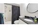 Well-lit bathroom featuring granite counters and a sleek black and white shower curtain at 2312 Java Plum Ave, Sarasota, FL 34232