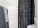 Bright bathroom with a black and white polka dot shower curtain and gray towel at 2312 Java Plum Ave, Sarasota, FL 34232
