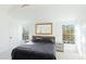 Sunlit bedroom with a king-size bed, large window views and a statement mirror at 2312 Java Plum Ave, Sarasota, FL 34232