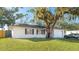Charming single-story home with lush lawn, mature shade tree, and attached garage at 2312 Java Plum Ave, Sarasota, FL 34232