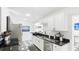 Modern kitchen with white cabinets, black countertop, and stainless-steel appliances at 2312 Java Plum Ave, Sarasota, FL 34232