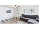 Cozy living room with a modern ceiling fan, black and white tile floor, and comfortable gray sofa at 2312 Java Plum Ave, Sarasota, FL 34232