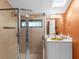 Bathroom features a walk-in shower, a stylish sink and an orange accent wall at 2613 Temple St, Sarasota, FL 34239