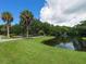 Scenic view of community pond with walking path, lush greenery, and blue skies with picturesque clouds at 2613 Temple St, Sarasota, FL 34239