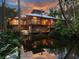 Stunning exterior elevation of unique wooden home with a tranquil pond reflecting a beautiful sunset at 2613 Temple St, Sarasota, FL 34239