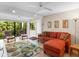 Inviting living room with an orange sofa, neutral walls, and views of the private, wooded backyard at 2613 Temple St, Sarasota, FL 34239