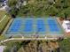 Aerial view of the community's four well-maintained, fenced tennis courts, surrounded by mature trees at 2613 Temple St, Sarasota, FL 34239
