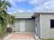 View of a home's exterior with palm tree and access doors at 2712 36Th Avenue E Ter, Bradenton, FL 34208