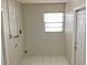 Utility room with tile floor, window, and access door at 2712 36Th Avenue E Ter, Bradenton, FL 34208