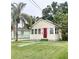 Charming, light yellow single story home featuring a well-kept lawn and a bright red front door at 3308 W Dewey St, Tampa, FL 33607
