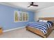 Bedroom with a wooden bed frame, striped bedding, and a bright window view at 3970 Country View Dr, Sarasota, FL 34233