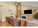 Bright living room features a fireplace, vaulted ceilings, tropical ceiling fan, and tile floors at 3970 Country View Dr, Sarasota, FL 34233