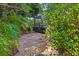 Secluded backyard patio space surrounded by lush greenery and mature trees at 3970 Country View Dr, Sarasota, FL 34233