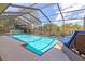 Beautiful pool in screened enclosure with lounge chairs and an umbrella at 3970 Country View Dr, Sarasota, FL 34233