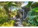 Enclosed patio area with tropical foliage surrounding a peaceful shaded backyard at 4062 S Shade Ave, Sarasota, FL 34231