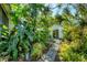 Backyard garden with lush tropical plants leading to a detached bonus room at 4062 S Shade Ave, Sarasota, FL 34231
