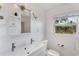 Bright bathroom featuring a single sink vanity, a stylish mirror and lighting at 4062 S Shade Ave, Sarasota, FL 34231