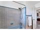 Traditional bathroom has an aqua colored bathtub and modern fixtures, along with gray tiled walls at 4062 S Shade Ave, Sarasota, FL 34231