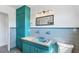 Turquoise bathroom features a vanity and sink along with matching blue tiling and a framed mirror at 4062 S Shade Ave, Sarasota, FL 34231