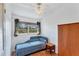 Sunlit bedroom features wood floors, a bed with blue patterned bedding and a window with green curtains at 4062 S Shade Ave, Sarasota, FL 34231
