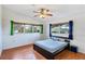 Cozy bedroom with wood floors, ample natural light from two windows, and a modern ceiling fan at 4062 S Shade Ave, Sarasota, FL 34231