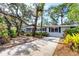 Charming single-story home with mature trees, a driveway, and lush landscaping at 4062 S Shade Ave, Sarasota, FL 34231
