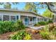 Inviting home with a covered front porch and lush tropical landscaping with a bright blue front door at 4062 S Shade Ave, Sarasota, FL 34231