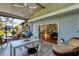 Covered patio with tile flooring, wicker furniture, a dining table, and views of lush landscaping at 4062 S Shade Ave, Sarasota, FL 34231