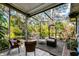 Screened patio with wicker furniture, a table and chairs, and views of the landscaped backyard at 4062 S Shade Ave, Sarasota, FL 34231
