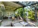 Covered patio offers tiled flooring, a dining table, outdoor seating, and views of the tropical backyard at 4062 S Shade Ave, Sarasota, FL 34231
