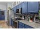 Modern kitchen with stainless steel appliances, granite countertops, and painted cabinetry at 4630 56Th E Dr, Bradenton, FL 34203